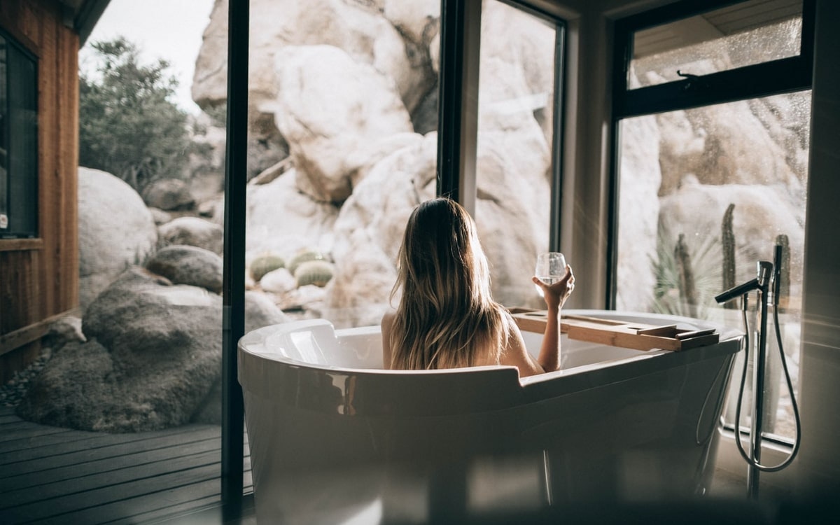 Frau in Badewanne schaut aus Fenster