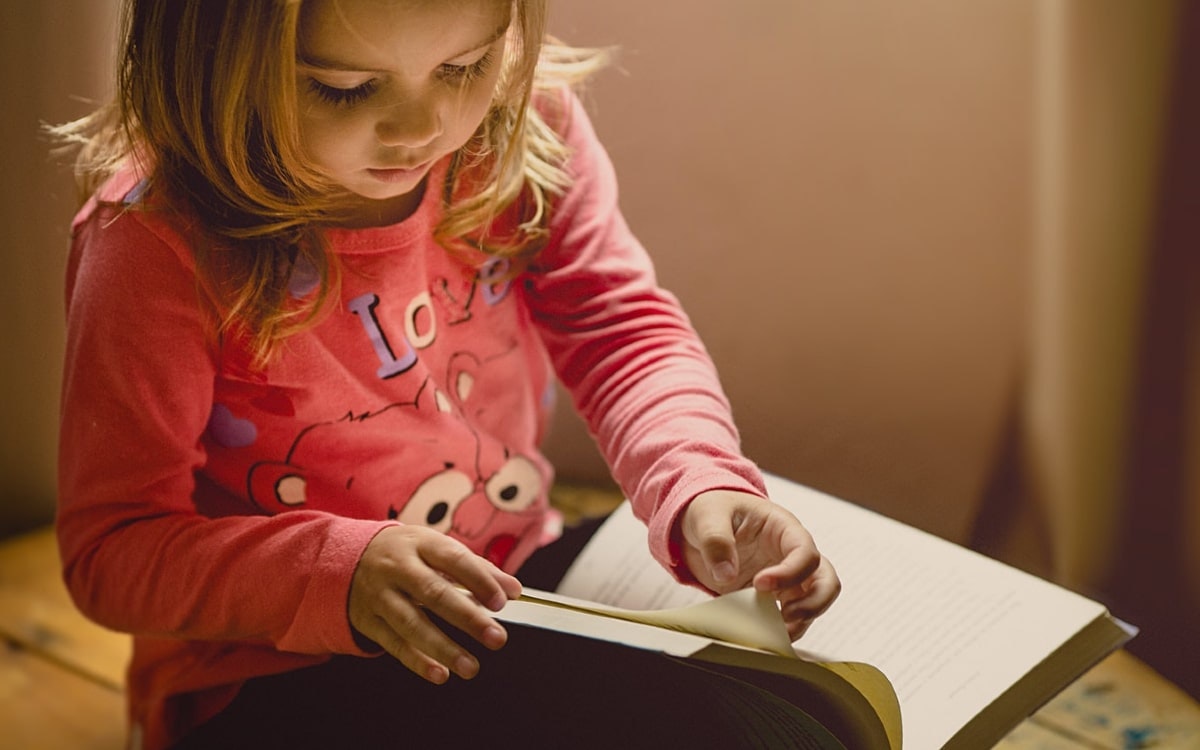 Geschenke zur Einschulung: Ein Mädchen liest in einem Buch