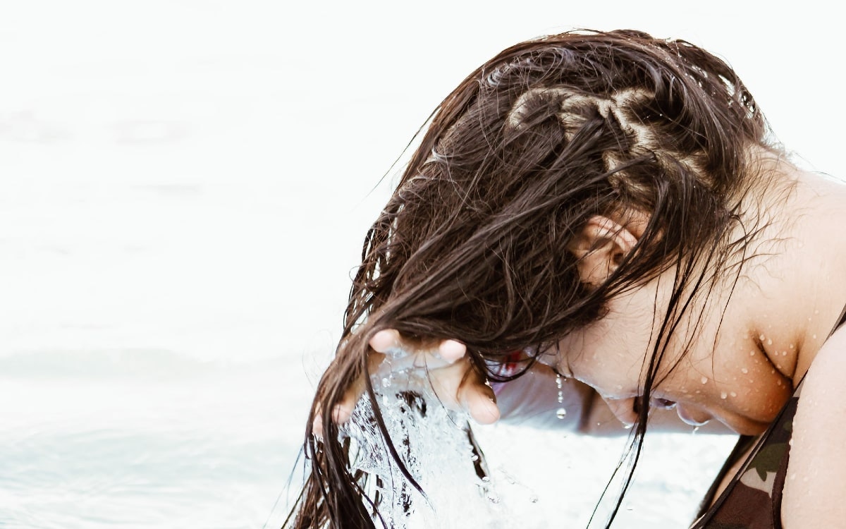 Eine Frau, die ihre Haare richtig pflegen muss, nachdem sie im kühlen Nass geschwommen ist