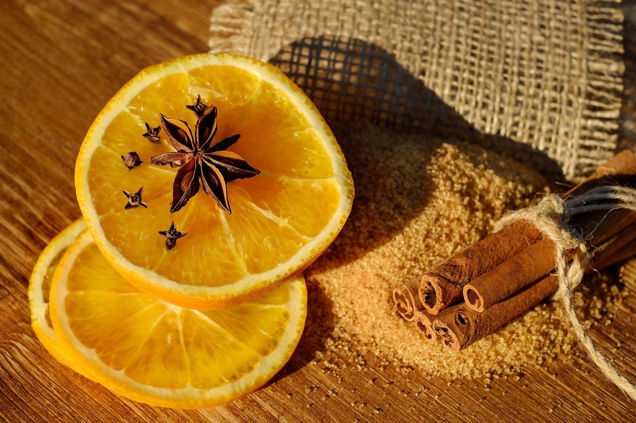 Glühwein selber machen mit Orangenscheiben, Nelken, Zimt und Zucker