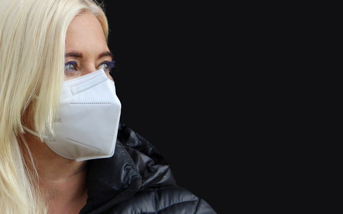 Blondine mit FFP2-Maske schaut zur Seite
