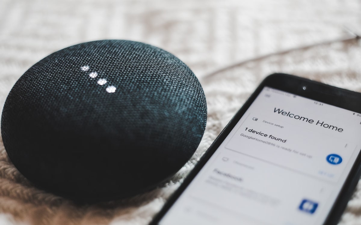 Smart Speaker liegt neben einem Smartphone
