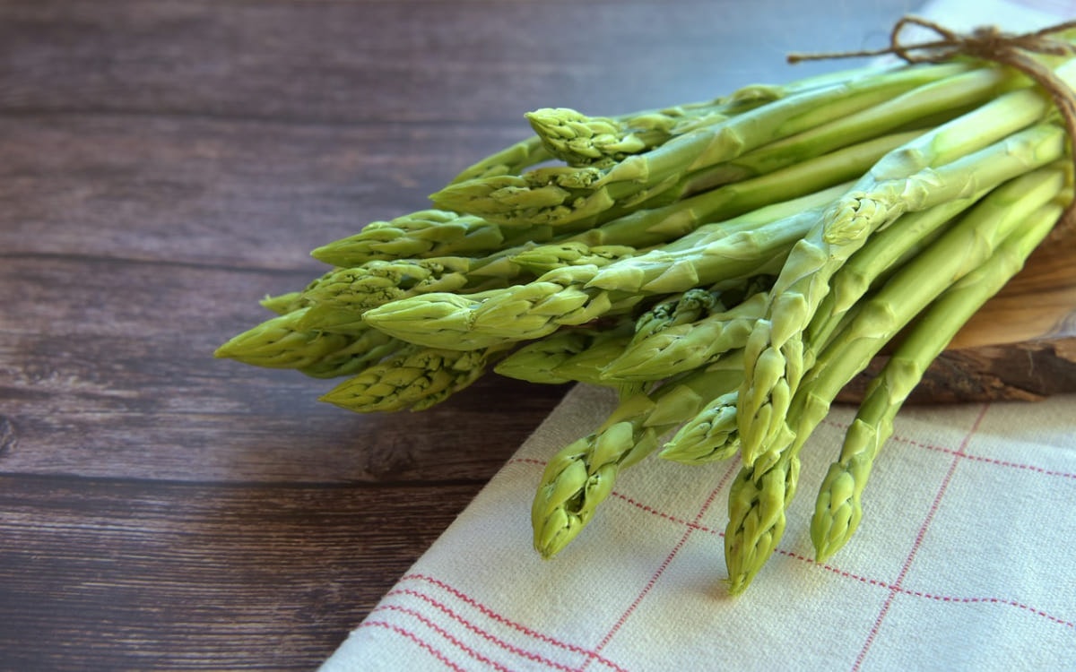 Grüner Spargel auf einem kleinen Holzbrett