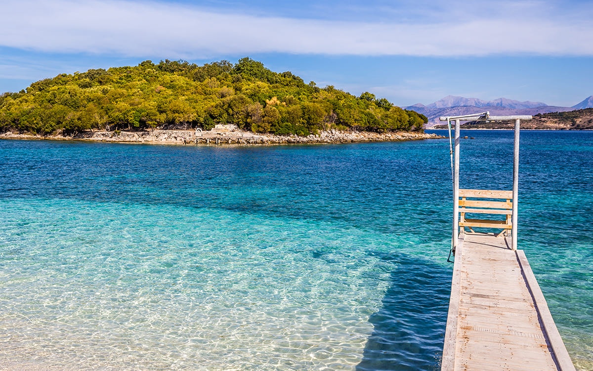 Türkisblaues, glasklares Wasser mit Steg im beliebten Badeort Ksamil