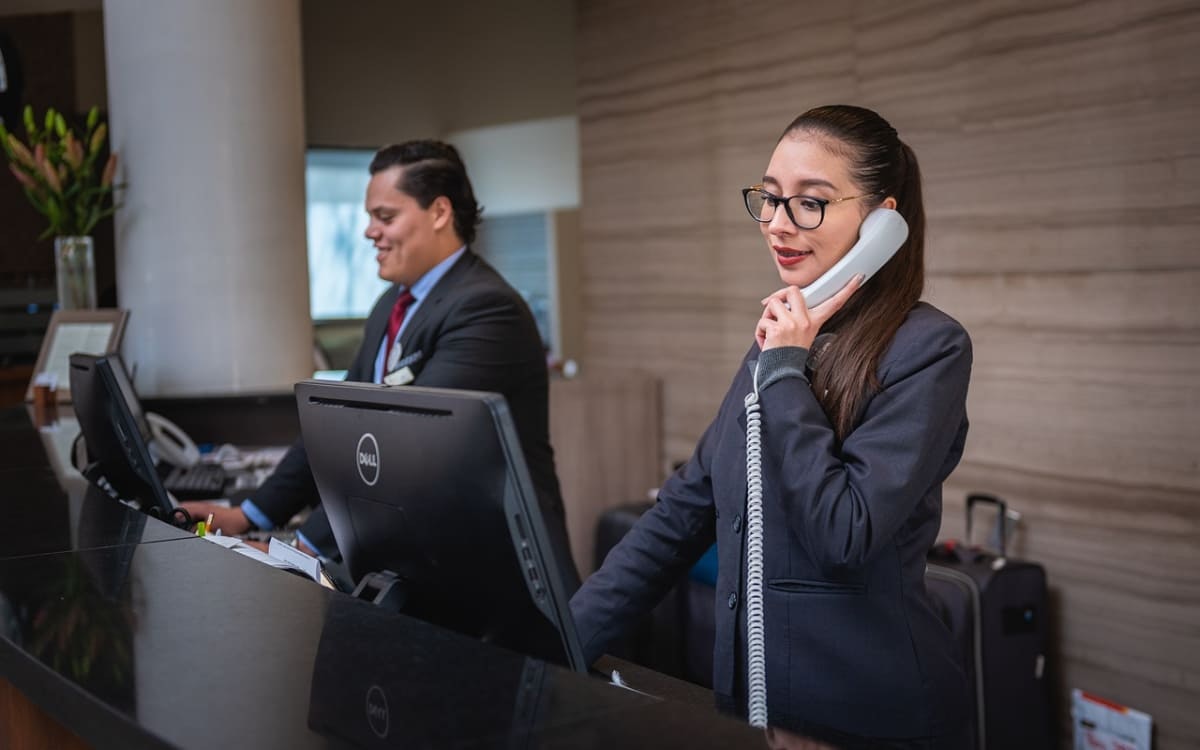Hotel-Rezeptionisten bei der Arbeit am Telefon und PC