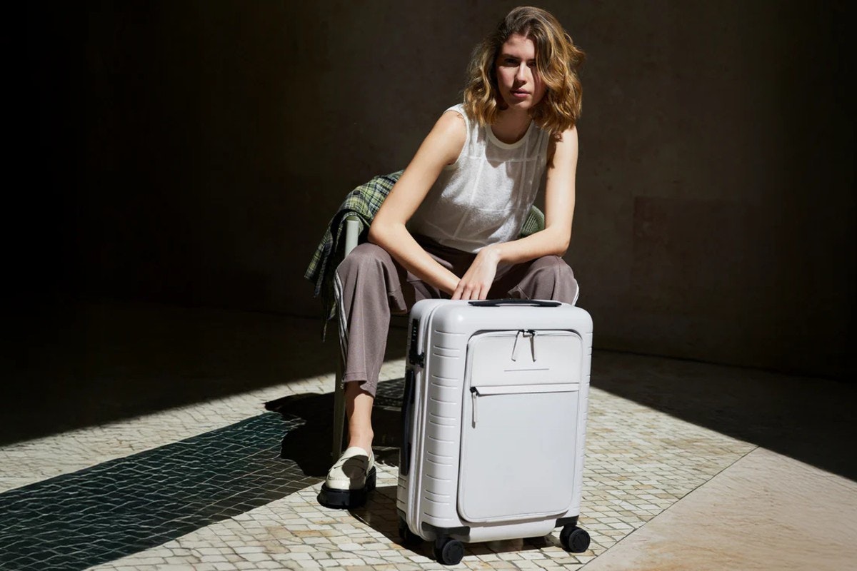 Eine Frau mit einem Horizn Studios Koffer.